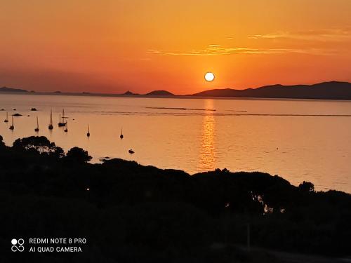 un coucher de soleil sur une étendue d'eau avec des bateaux dans l'établissement La Civita Piétrosella, à Pietrosella