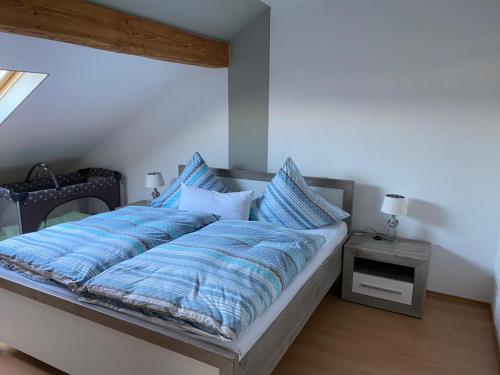 a bed with a blue comforter and pillows on it at Ferienwohnung Hub in Nittel