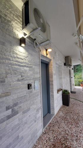 a stone wall with a door and a fan at Oasis in Kallithea Halkidikis