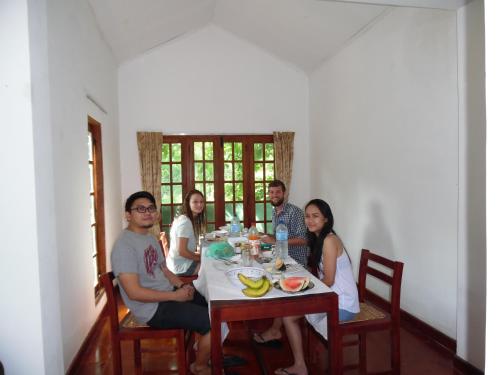 un grupo de personas sentadas alrededor de una mesa en Linwood Bungalow, en Kandy