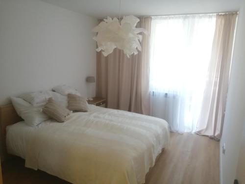 a bedroom with a white bed and a large window at EASY RENT Apartments- Kazimierz Dolny Doły 4 lok 4 in Kazimierz Dolny