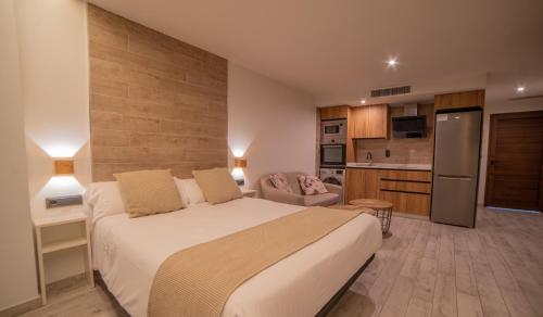 a bedroom with a large bed and a kitchen at Estudio Los Olivos in Alcalá del Júcar