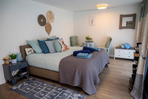 ein Schlafzimmer mit einem großen Bett mit blauen Kissen in der Unterkunft Le Val des Cerfs - Het Hertendal in Hastière-par-delà
