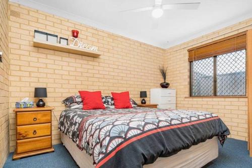 ein Schlafzimmer mit einem Bett und einer Ziegelwand in der Unterkunft Comfortable Central Unit in Geraldton