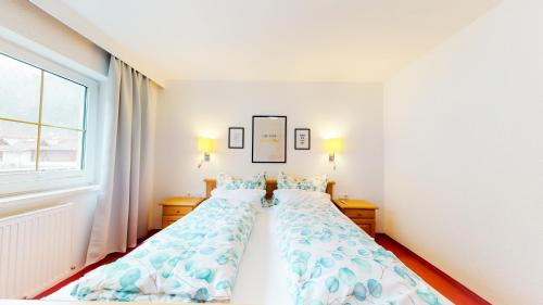 2 Einzelbetten in einem Schlafzimmer mit Fenster in der Unterkunft Wohnhaus Christoph in Längenfeld