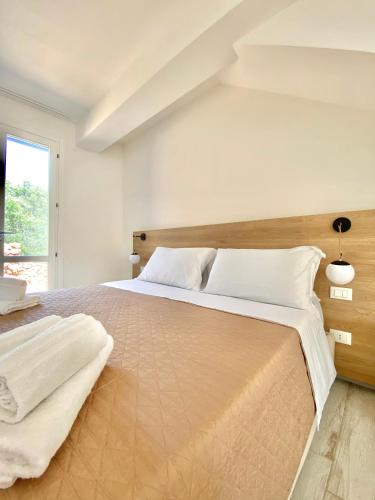 una camera bianca con un grande letto con cuscini bianchi di Bilocale Punta Basano a Marettimo