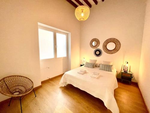 1 dormitorio con cama, ventana y silla en Apartamento playa del Postiguet, en Alicante