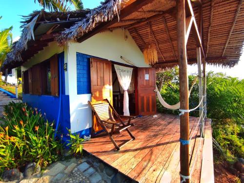 a house with a deck with a chair on it at Le Grand Bleu in Andilana