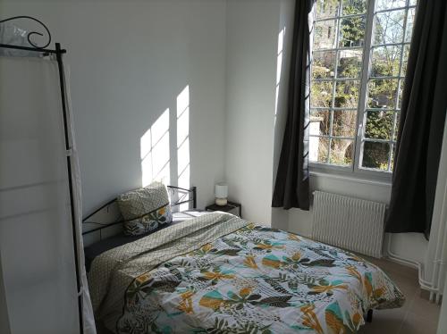 um quarto com uma cama com um edredão e 2 janelas em O'Couvent - Appartement 91 m2 - 4 chambres - A521 em Salins-les-Bains