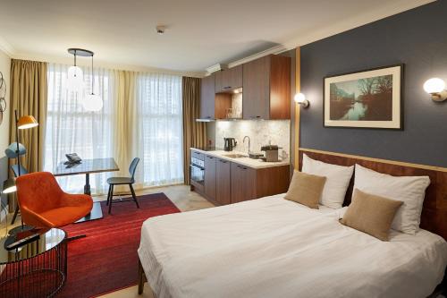 um quarto de hotel com uma cama e uma cozinha em Nova Apartments Amsterdam em Amesterdão