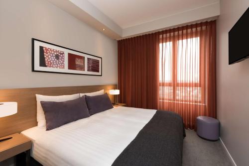 a hotel room with a bed and a window at Adina Apartment Hotel Frankfurt Neue Oper in Frankfurt