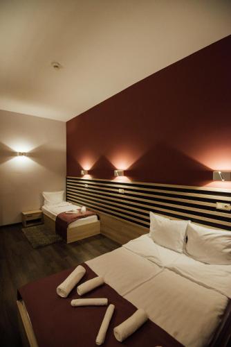 a hotel room with two beds with two slippers on them at Altus Hotel & Spa in Praid