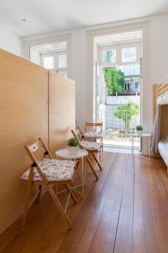 a room with chairs and a table and a window at Porto Lounge Hostel & Guesthouse by Host Wise in Porto
