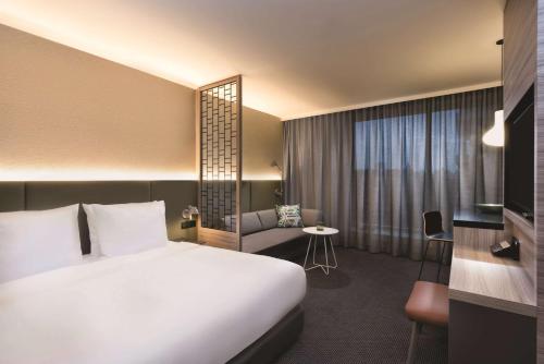 a hotel room with a white bed and a couch at Adina Apartment Hotel Hamburg Speicherstadt in Hamburg