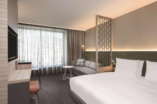 a hotel room with a large bed and a chair at Adina Apartment Hotel Hamburg Speicherstadt in Hamburg