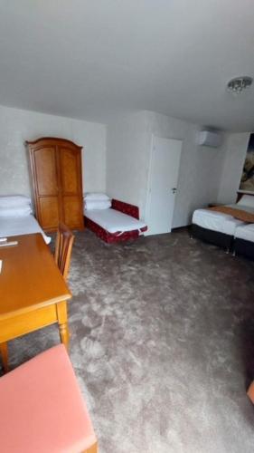 a room with two beds and a table and a desk at A SZELLŐ in Domonyvölgy