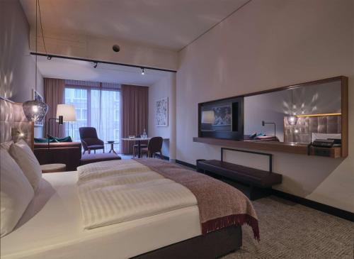 a bedroom with a large bed and a living room at Adina Apartment Hotel Nuremberg in Nuremberg