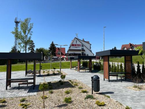 a group of benches in a park with a building at Motel Na Zbójeckiej in Skawa