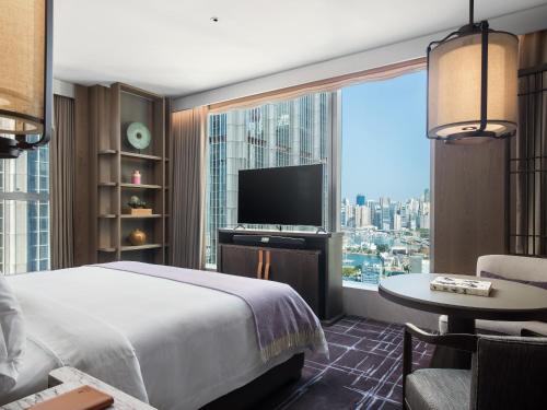 a hotel room with a bed and a large window at The St. Regis Hong Kong in Hong Kong