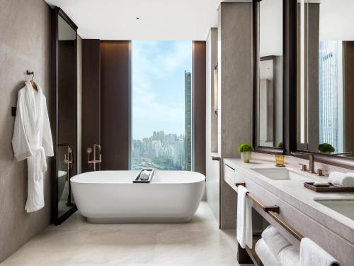 baño con bañera, 2 lavabos y ventana en The St. Regis Hong Kong en Hong Kong