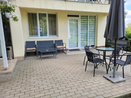 a patio with a table and chairs and an umbrella at Capra Vecinului in Târgu-Mureş