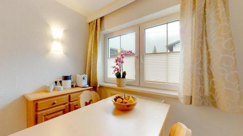 a kitchen with a table and a window with a bowl of fruit at Zimmer Enzian in Längenfeld