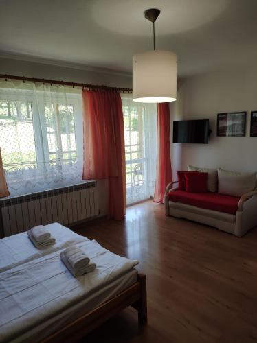 a living room with a bed and a couch at Rezydencja Bukowy Dwór in Czarna