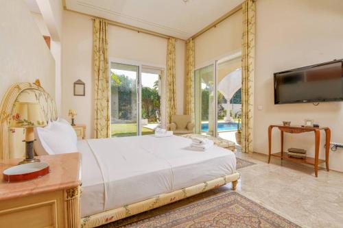 a bedroom with a large bed and a tv at Authentique in Sukrah