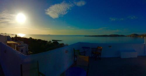 a view of the ocean from a balcony with chairs at Nostos Studios in Parikia
