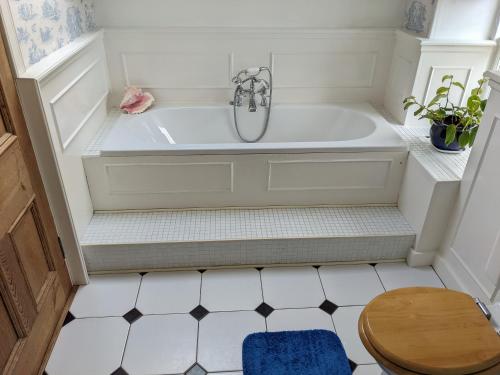 a bathroom with a tub and a wooden stool at Black Isle Bed and Breakfast in Avoch