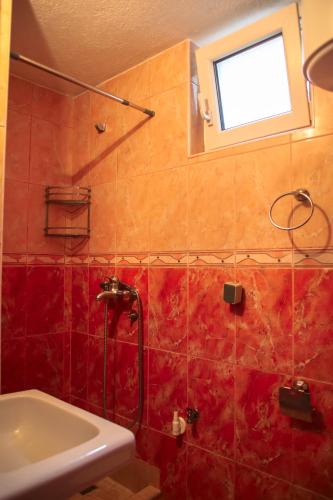 bagno con doccia, lavandino e finestra di Apartment Mimo a Mostar