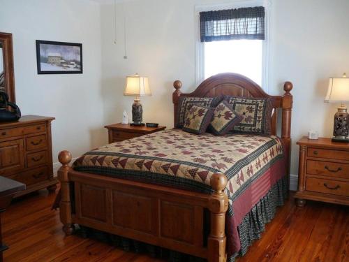 a bedroom with a wooden bed with two dressers and a window at A Awesome Shenandoah Valley View in Elkton