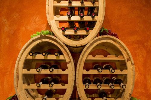 a wall with three wooden wine racks with wine bottles at Wellness- und Schneesporthotel Christiania in Saas-Almagell