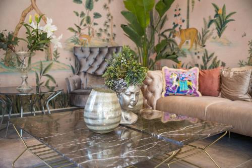 a living room with a couch and a table with a vase at Niss Lara Hotel in Antalya