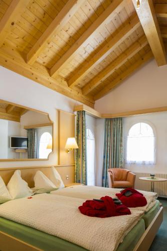 a bedroom with a large bed and a chair at Wellness- und Schneesporthotel Christiania in Saas-Almagell