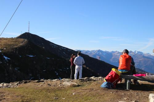 a group of people sitting on a bench on a mountain at Sachserhof Ferienwohnungen in Sachsenburg in Sachsenburg