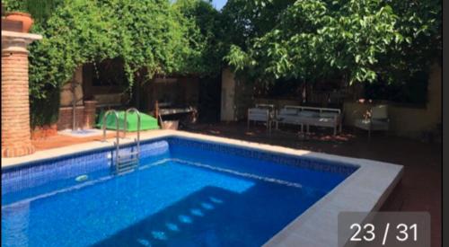 una gran piscina en un patio con árboles en casa rural LAS CHIMENEAS, en Casasimarro