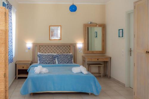 ein Schlafzimmer mit einem blauen Bett mit zwei Handtüchern darauf in der Unterkunft Modi Resort in Xiropigado