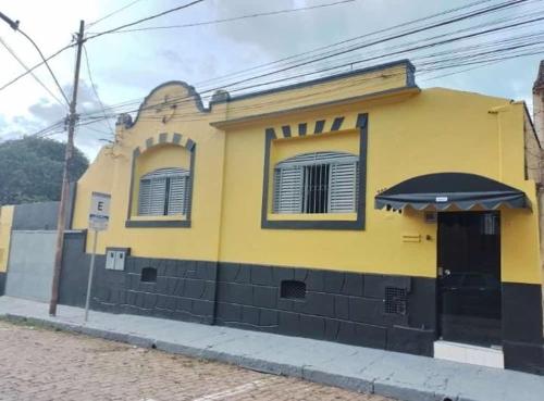 a yellow building with an umbrella on a street at Pousada uberaba in Uberaba