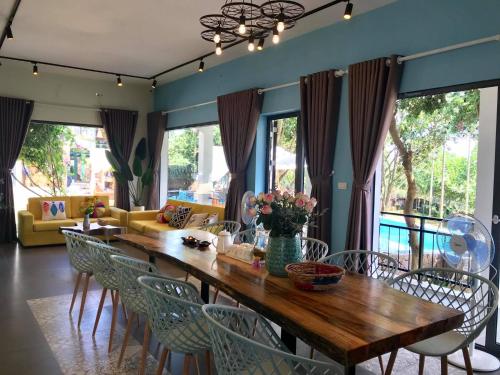 een eetkamer met een houten tafel en stoelen bij The Kefi House - Villa Hoa Giấy in Ba Vì