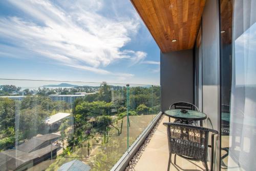 a balcony with a table and chairs and a view at Calypso Garden Residences by Beringela in Phuket Town