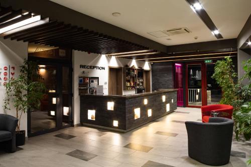 eine Lobby eines Restaurants mit einer Bar mit Lichtern in der Unterkunft Altus Hotel & Spa in Praid