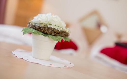 a white flower in a white cup on a table at Wellness- und Schneesporthotel Christiania in Saas-Almagell