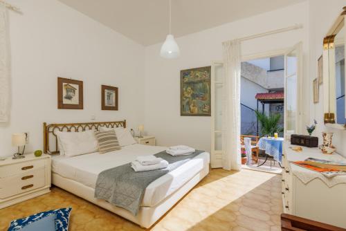 Un dormitorio blanco con una cama y un balcón. en Villa in the Garden, en Kokkíni Khánion