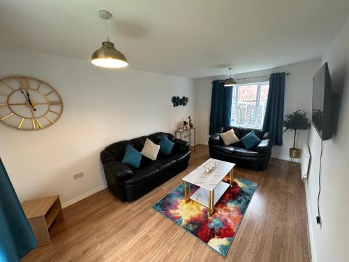 a living room with a couch and a table at Trinity's Place in Wythenshawe