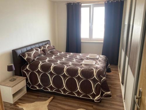 sypialnia z łóżkiem z niebieskimi zasłonami i oknem w obiekcie 2 Rooms Apartment in Michalovce w mieście Michalovce