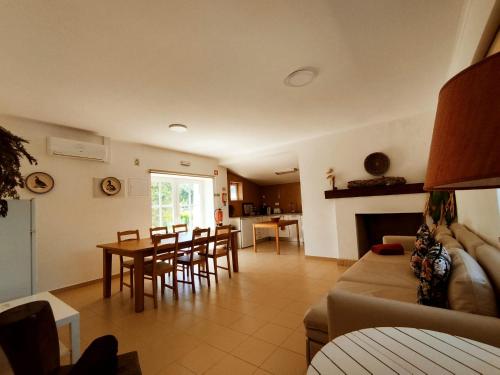 een woonkamer en een keuken met een tafel en stoelen bij Casa do Pomar in Sesimbra