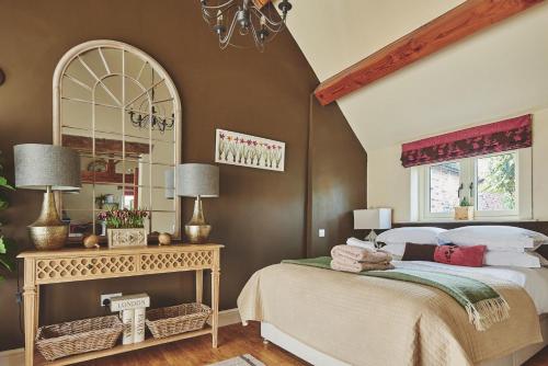 um quarto com uma cama grande e um espelho em The Couple's Retreat em Ashbourne