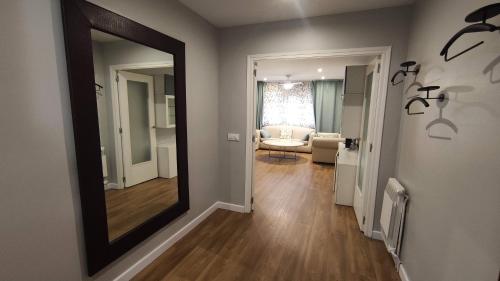 a hallway with a mirror and a living room at SUITEDREAMS - Avet 31 in Andorra la Vella
