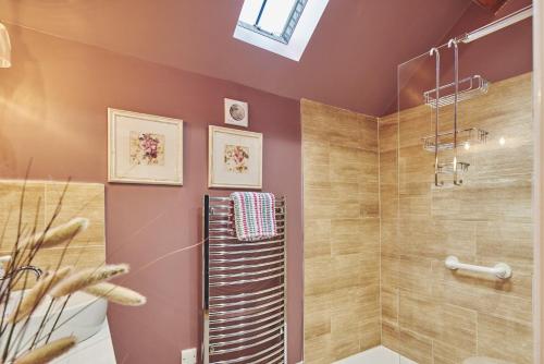uma casa de banho com uma cabina de duche ao nível do chão ao lado de uma cabina de duche em vidro. em The Couple's Retreat em Ashbourne